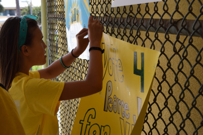  A freshmen running for Vice President hangs a poster just outside the Mustang Mall during lunch