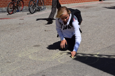 Freshmen Lori Strauss campaigns using chalk outside the pool between fifth and sixth period