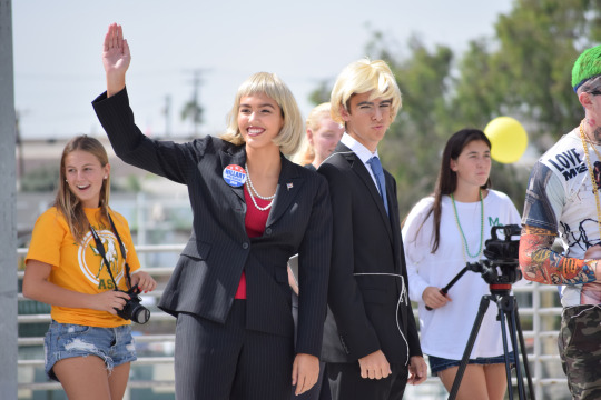 Danielle Gonzales, dressed up as Hillary Clinton, is waving to the Costa students after finishing her first homecoming court activity.