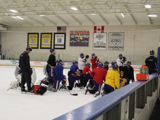 Cade and his team huddle around their coach as he teaches them new techniques and strategies to use on the ice.
