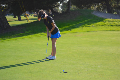 Varsity player Klara Nagy sinks a put at the 13th hole for a bogie of 4.