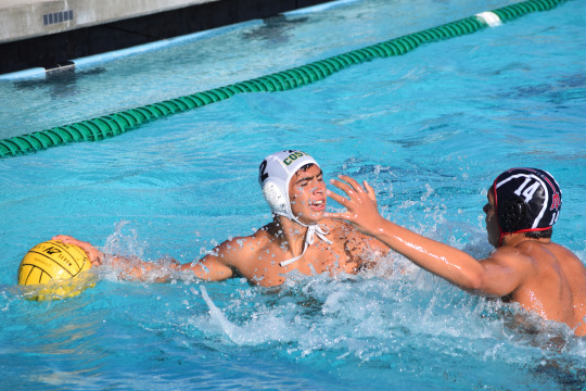 Junior, Alex Nahabed looks for a open player swimming to goal, while having high pressure from a PV defense-man.