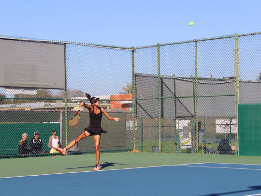 Freshman Varsity player Audrey Vo follows through with an overhead serve to the other team. 