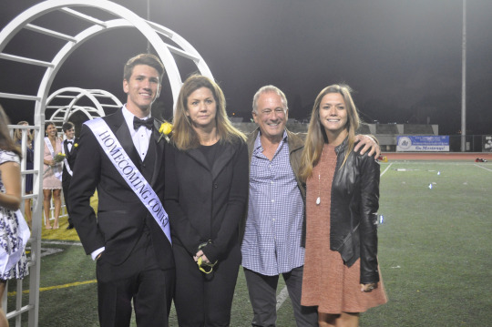 The members of Duke Mahr’s family come together to take a family photo while the homecoming video is being played for the crowd. 