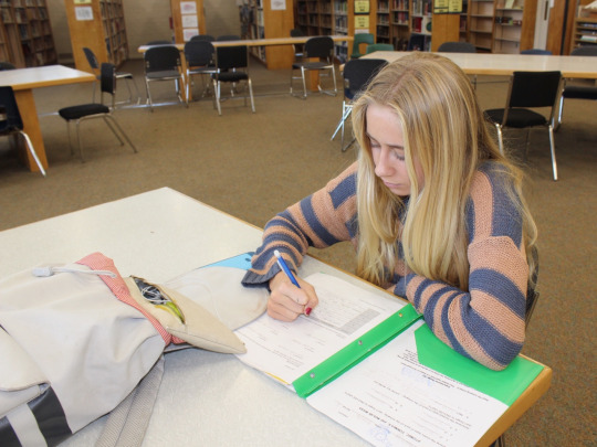 Sophomore Riley Hazelrigg works on her homework at the library during break. Students have been using the library’s facilities for years, which has been a helpful resource to lighten their workload or complete their assignments.
