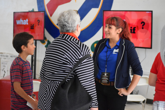 A U Code volunteer explains to a grandmother and student that their program inspires students to reach their creative and intellectual potentials through computer science.