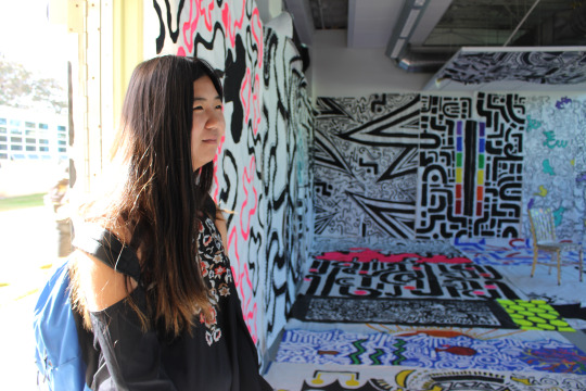Sophomore Nicole Matsumoto views the art gallery in Room 60 at lunch on Wednesday. The art gallery, “To the Windows to the Walls”, was put together by the Art 1 and 2 class and is showcased this week to the public.