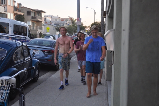 After the strenuous workout the surf team members walk along the sidewalk outside Level 10 Fitness to catch their breath. 
