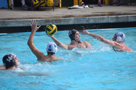 Two Loyola defenders defend Mira Costa player trying to win the ball.