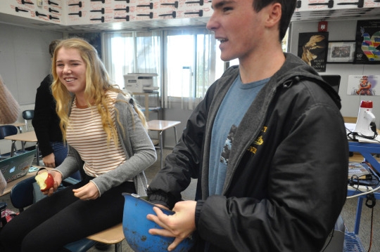 Mira Costa High School juniors Liam Cook (right) and Grace Lauson (left) pick names for Secret Santa out of the Peacekeeper helmet this Monday at lunch. Several Model United Nations students gathered together in Mr. Timberlake’s room to pick names that were written on small pieces of paper in the helmet. 