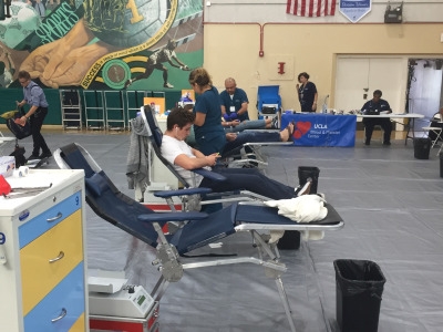 A UCLA hospital employee prepares to draw blood from a donating student.