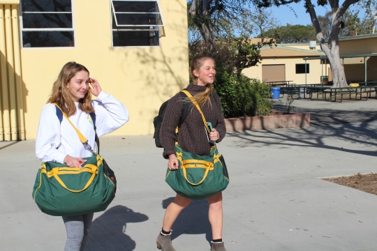 Juniors Jenny Stowt and Reyna Workman leave campus during the beginning of 5th period for a water polo tournament at Rosary Academy. They had just been excused to leave and are ready for the first tournament of the year. 