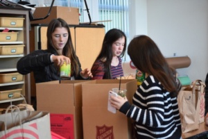 Three ASB members load canned goods into boxes, which will be handed out to the less fortunate.