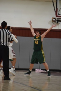 Senior Jacob Magleby keeps his hands up in defense of a Torrance player during the boys basketball game on Tuesday night in the Torrance High School gymnasium.