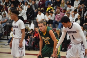 Senior Cameron Steen stands on the key during a free throw shot, guarding two Torrance opponents.