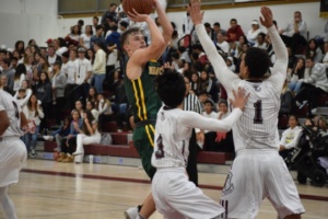 Ryan shoots the basket while having high pressure put on him by two Torrance defenders.