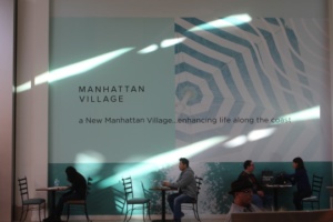 Mall-goers spend time at the new tables outside of the apple store under a construction sign.