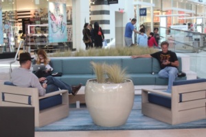 Three people use the new seating areas in the mall to use technology.