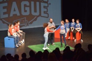 Red team captain (Dalia Feliciano) and blue team captain (Claire Layden) shake hands center stage before the match begins. The captains represented and led their colored team during the match.