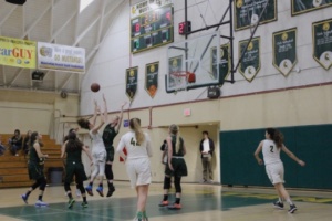 Girls varsity basketball players jump for the ball and attempt to tip it to one of their teammates. Costa received the ball and made the basket.
