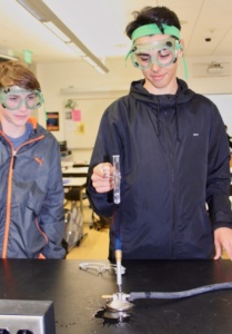 Sophomores Ethan Ward (right) and Reed Hilyard (left) place a test tube over the Bunsen burner in attempt to convert baking soda and hydrochloric acid into salt during Mrs. Neilson’s second period chemistry class. The students conducted the experiment at the beginning of class.