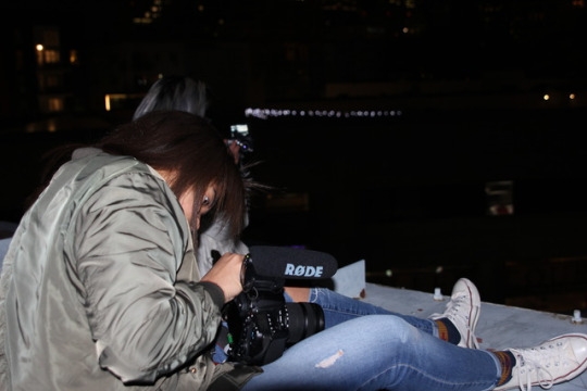 Later that evening on top of a parking lot in Little Tokyo, Mia Finney prepares her camera to take a shot of the night skyline. Good society had planned to go on top of roof tops in order to take photos of the Downtown LA skyline.