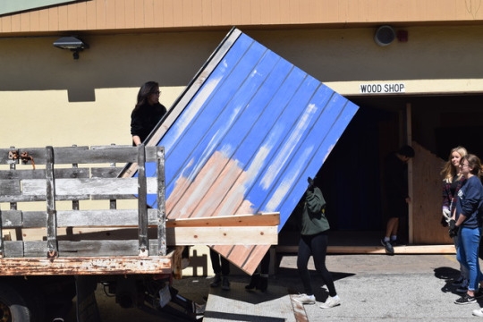 Students in Mira Costa’s wood shop class, including Sophomore Merrick Baldo, load a large wooden board into the bed of a Manhattan Beach Unified School District pickup truck during fifth period in the quad. Students in wood shop disassembled sets from previous drama productions to use for their projects.