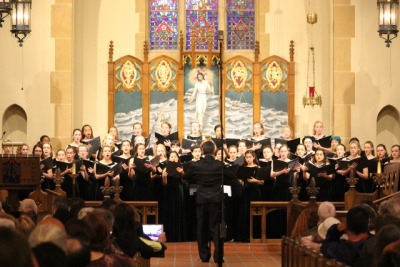 The Advanced Women’s Choir reads their music from their books while performing in front of lots of people at the church. Before the performance Rev. Rachel Anne Nyback and Choir Director Micheal Hayden spoke.