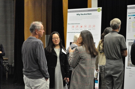 Community members discuss their opinions on the plans for the sports facilities while at the open house. Throughout the open house many groups of people came to share their opinions and learn more about Measure EE. 