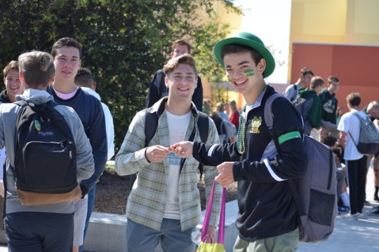 Junior Alex de Sousa(right), running for senior class vice president, hands a piece of candy to Lucas Prenter(left) during election week. De Sousa handed out candy during snack and lunch to campaign for being Costa’s senior class vice president.