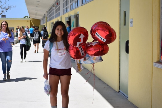 Sophomore Emma Doyle, running for ASB secretary, holds up an abundance of red balloons that read “Doyle” on one side and an arrow on the opposite side. Doyle also campaigned through wearing her designed shirts and necklaces. 