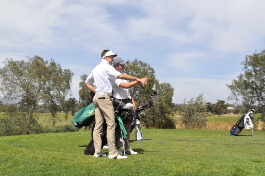 Senior Jack Raney (left) and Junior Connor Bergin (right) discuss the conditions of the hole before starting. The golf team played in their match at the Victoria Golf Course in Carson, California. 