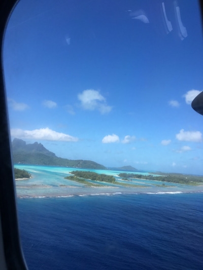 A flight arriving in Bora Bora is close to arriving at the local airport that is surrounded by crystal clear, turqouise waters. The flight departed from Los Angeles where the people waited 11 hours to finally reach their destination.