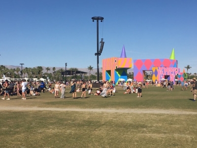 People lounge under the towering boxed animals while they take in the scenery at Coachella. The structures had vibrant colors and each wore their own party hat.