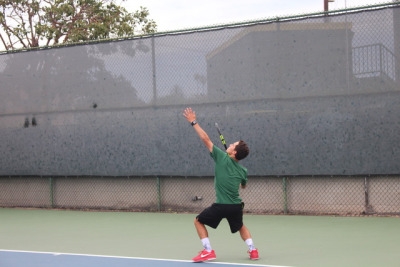Freshman Luca Mandela serves the ball to the other team to warm up his serve. The team warmed up their serving for 10 minutes before their practice started. 