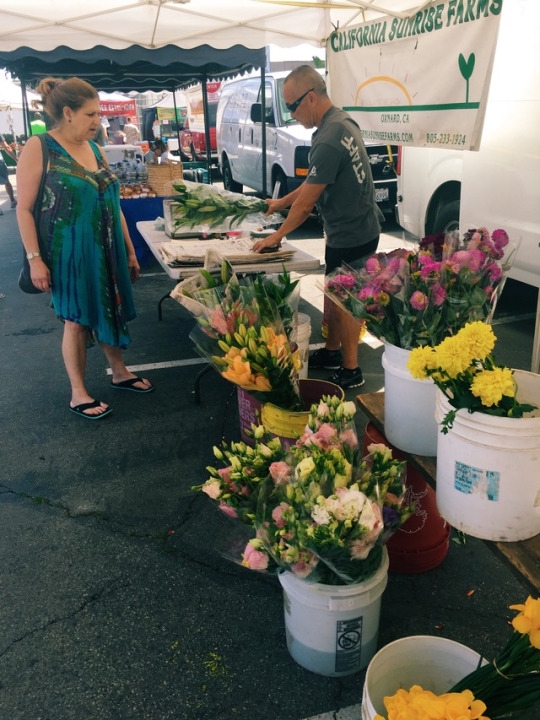 A local customer buys fresh flowers from an entrepreneur. The Hermosa Beach Farmers Market also sold flowers and decorations from California Sunrise Farms. 