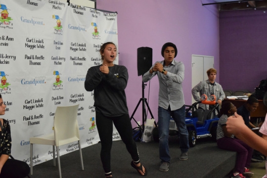Hailey Stazkow leads her class in song from the stage at the front of the class. Stazkow helped teach her group a choreographed song and dance to add a musical element to their theater production.