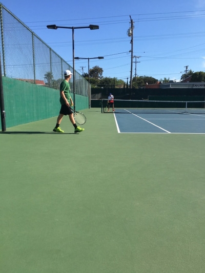 Michel walking up to the line to serve his serve that is the game winning point. Michel was aiming down the line he made the serve but lost the point and the match.